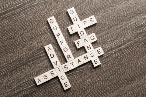 Feedback assistance support guidance words spelled with cubes on wooden table. 