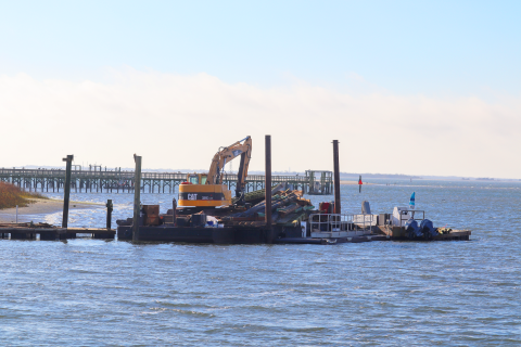 A photo of a docked barge carrying construction equipment.