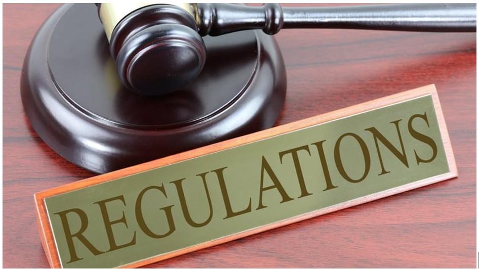 gavel and "regulations" sign on desk